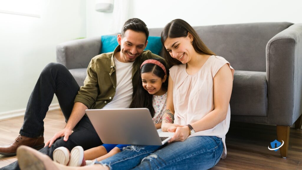 Parents and child looking at a laptop screen together.